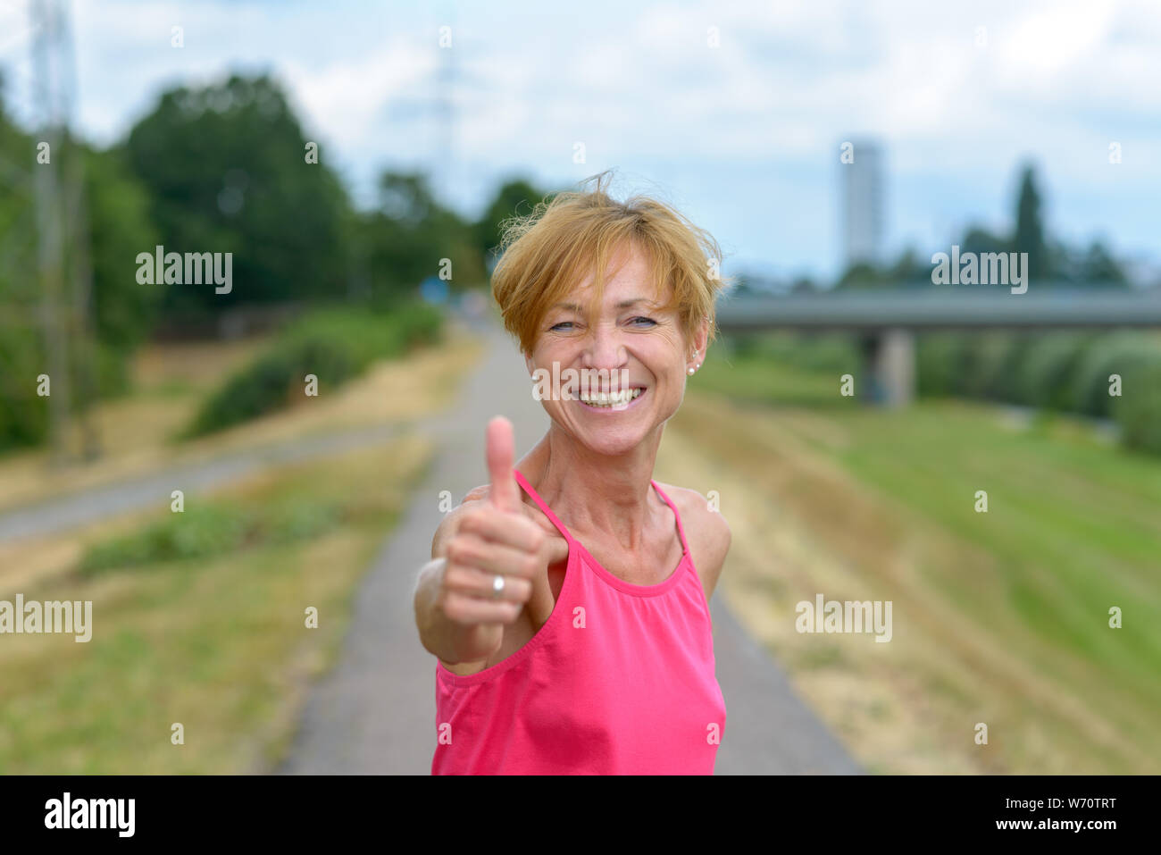 Enthusiastic woman giving a thumbs up gesture with a beaming gleeful smile as she celebrates a personal success or shows her support and agreement Stock Photo