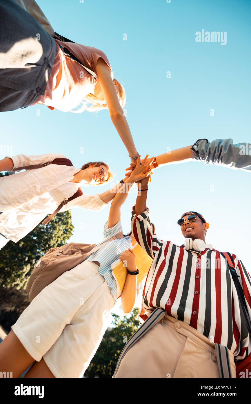 Group of students holding their hands together Stock Photo - Alamy