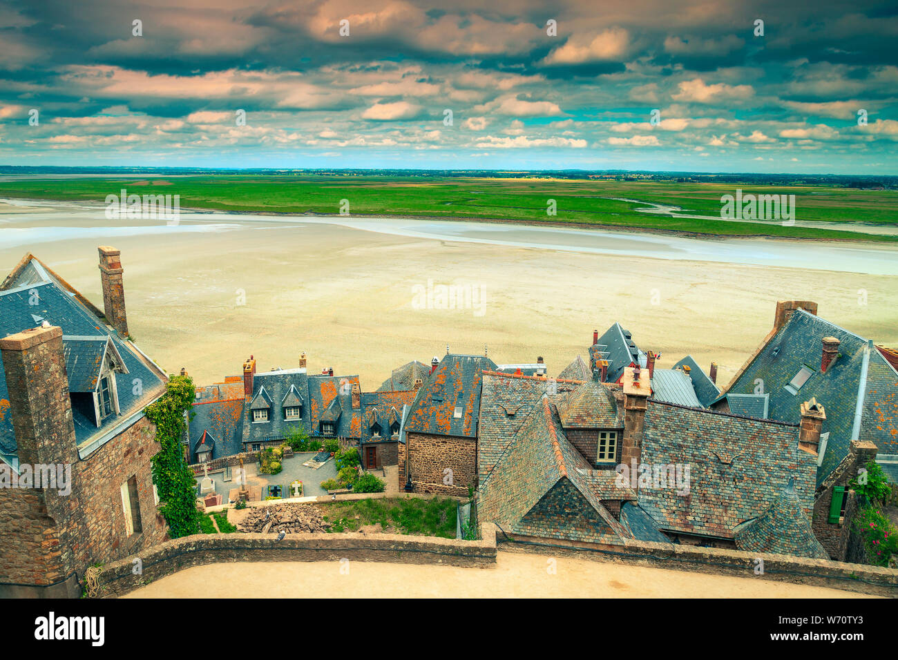 Famous travel and excursion place. Old stone houses with gardens and tidal island. Breathtaking view from the village of Mont Saint Michel, Normandy, Stock Photo