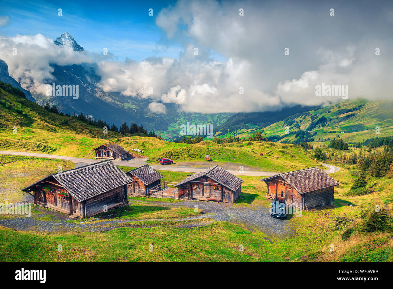 Popular touristic and travel location, alpine meadows and wooden rural farmhouses, Swiss Alps in background, Grindelwald, Bernese Oberland, Switzerlan Stock Photo
