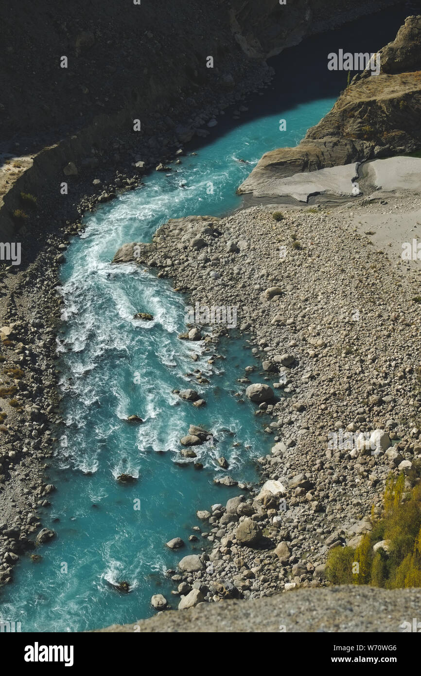 Above view of fresh water of winding turquoise blue river flowing through Karakoram mountain range. Gilgit Baltistan, Pakistan. Stock Photo