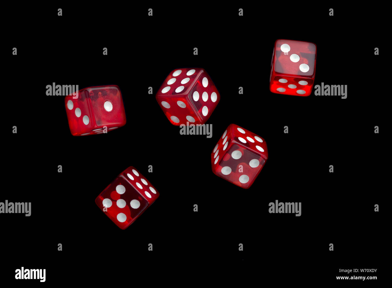 five falling translucent  red dices with white dots on black background Stock Photo
