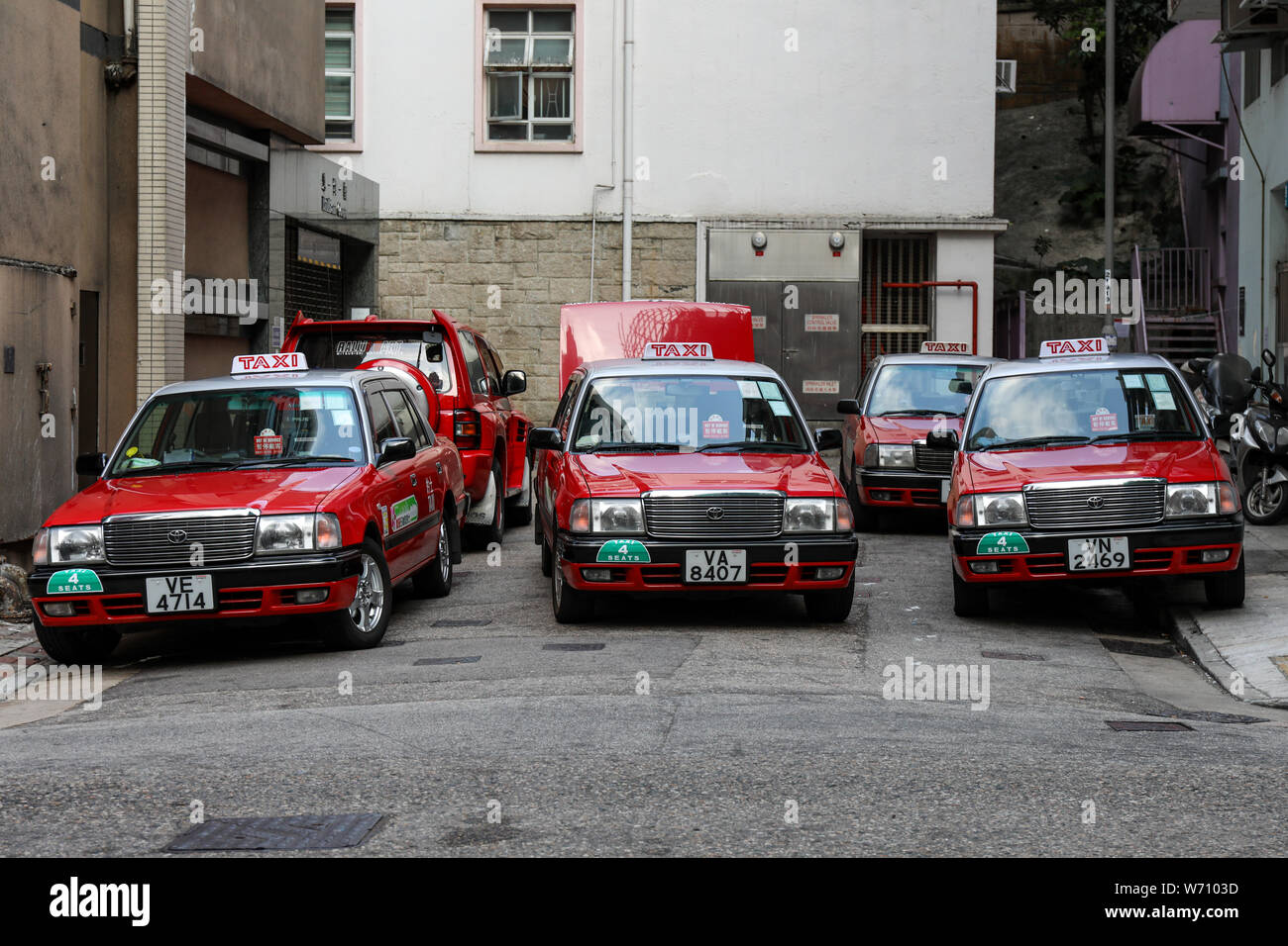 Red urban taxicabs having a break at the end of dead-end street in Wan Chai, Hong Kong Stock Photo