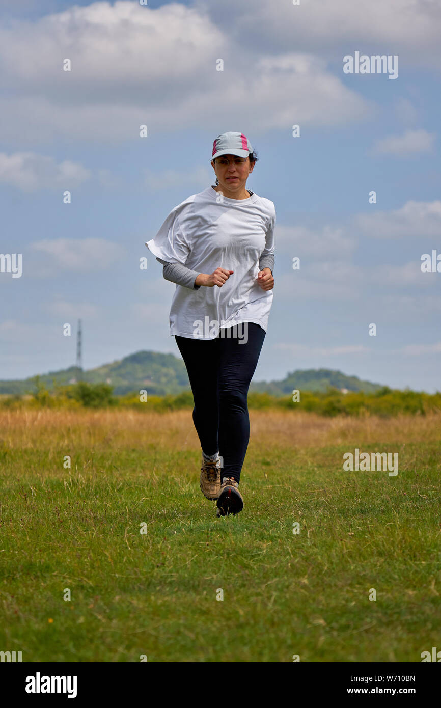 Spanish woman running on meadow Stock Photo Alamy