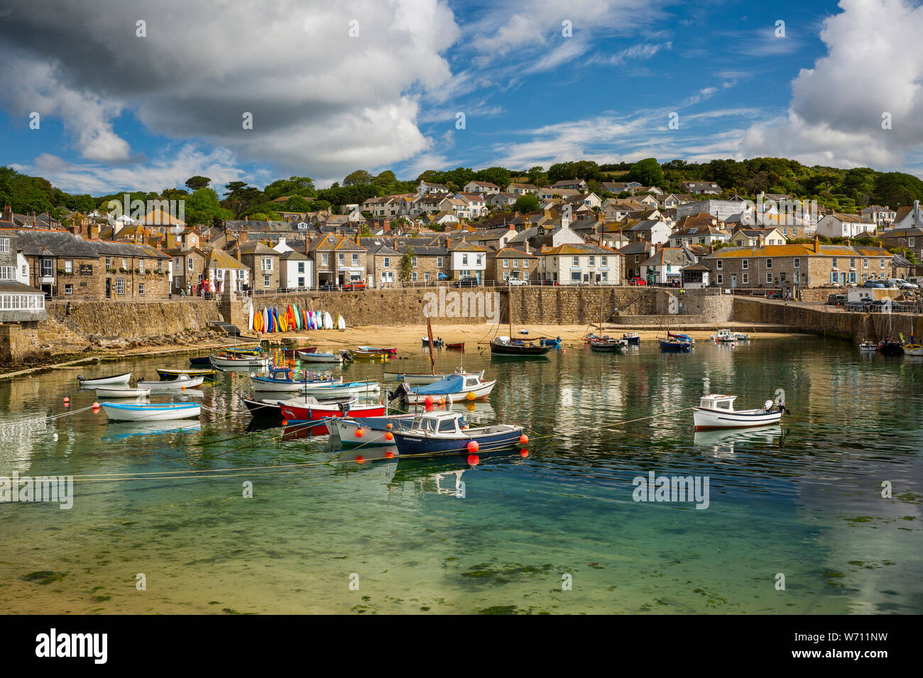 UK, England, Cornwall, Mousehole, boats moored in harbour at low tide below South Cliff Stock Photo
