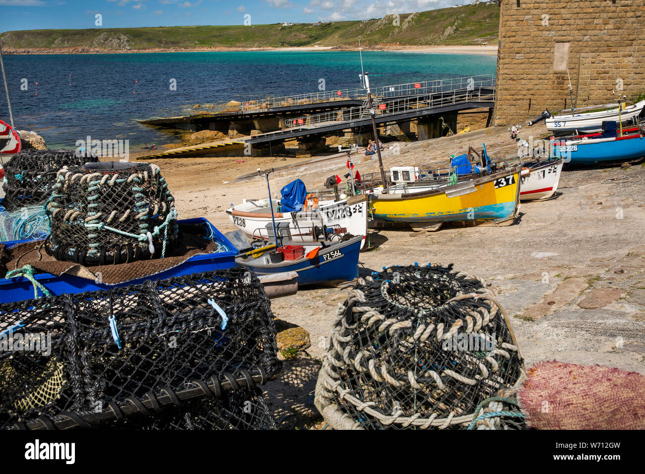 UK, England, Cornwall, Sennen Cove, lobster pots and fishing boats beside RNLI lifeboat station slipway Stock Photo