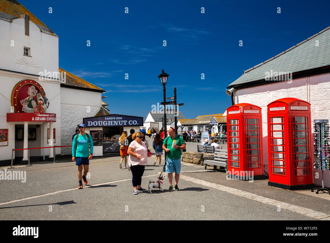 UK, England, Cornwall, Sennen, Land’s End Experience, visitors at two old red K6 phone boxes, by Aardman presents A Grand Experience attraction Stock Photo
