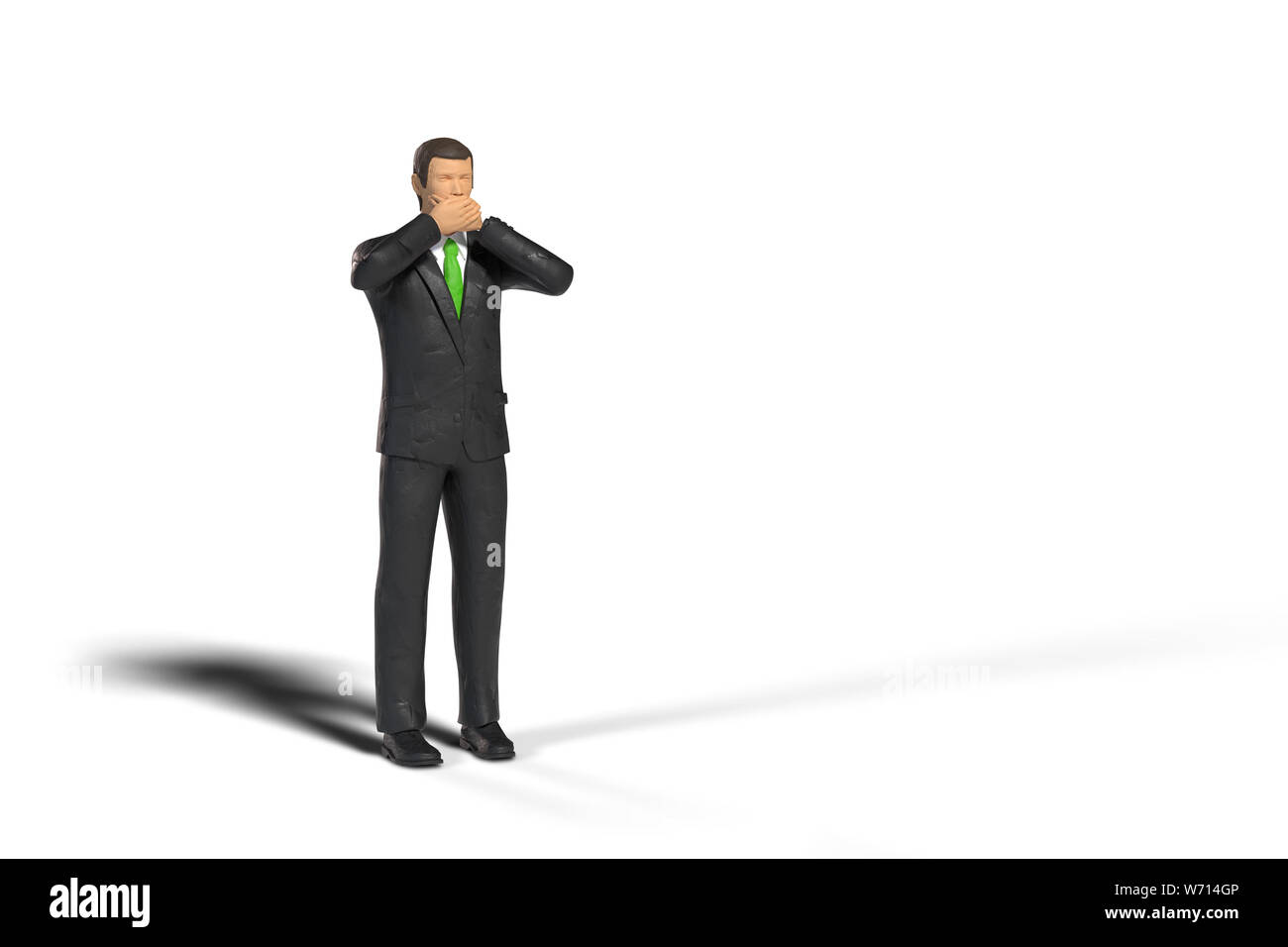 toy miniature businessman figure covering his mouth in front of empty space, concept isolated with shadow on white background Stock Photo