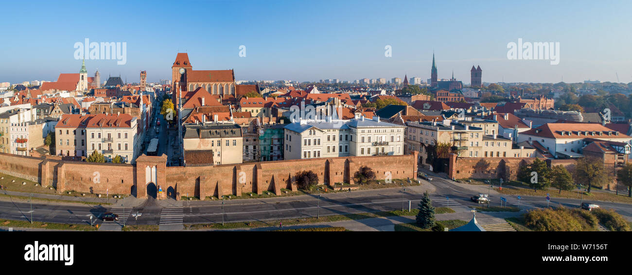 Wide aerial panorama of Torun Old City in Poland with Medieval Gothic Cathedral of St. John, town hall clock tower, churches, defensive wall and city Stock Photo