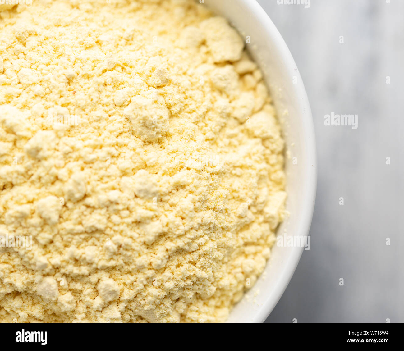 Nigerian dried pap (cornmeal or corn starch) in a white bowl, off centre to the left Stock Photo