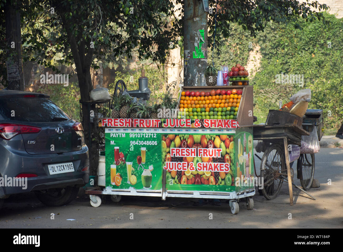 Indian people sale and buy juice shake fruits vegetables from small local grocery stall shop at Janpath Market and Dilli Haat bazaar on March 18, 2019 Stock Photo