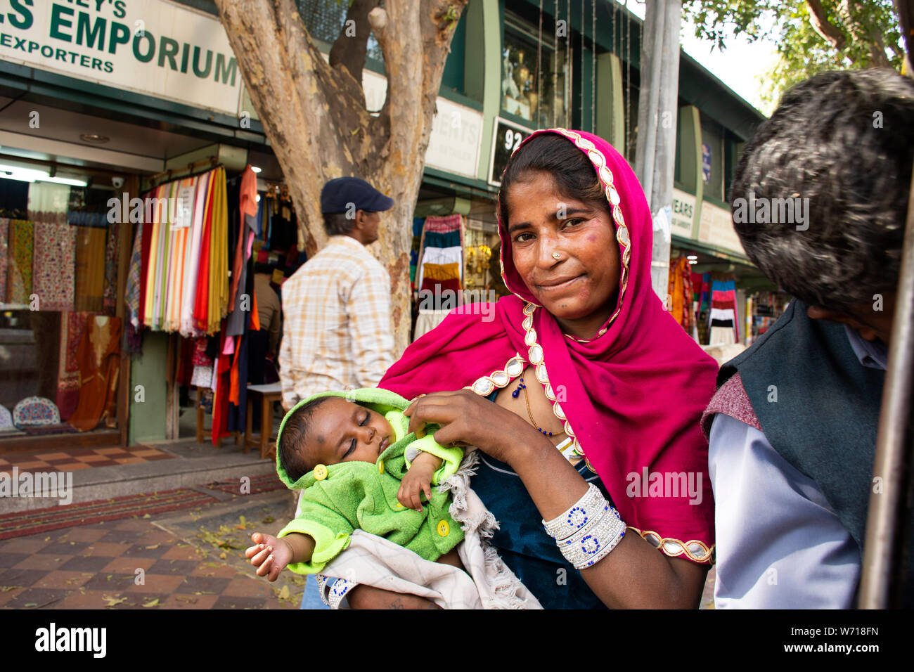Indian women beggar or untouchables caste hold baby and begging money from travelers people at Janpath Market and Dilli Haat bazaar on March 17, 2019 Stock Photo