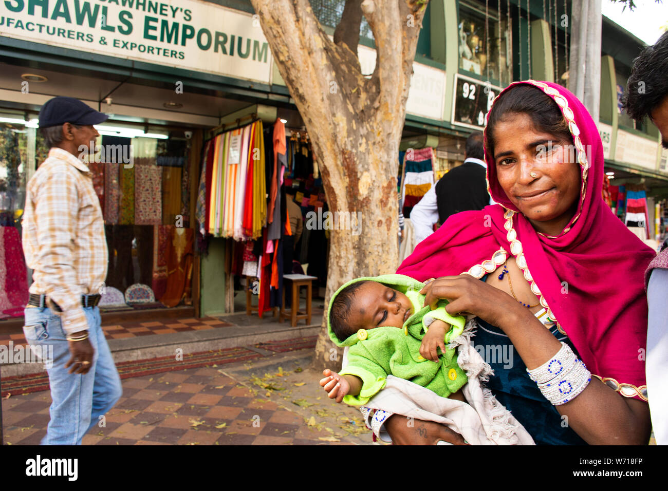 Indian women beggar or untouchables caste hold baby and begging money from travelers people at Janpath Market and Dilli Haat bazaar on March 17, 2019 Stock Photo