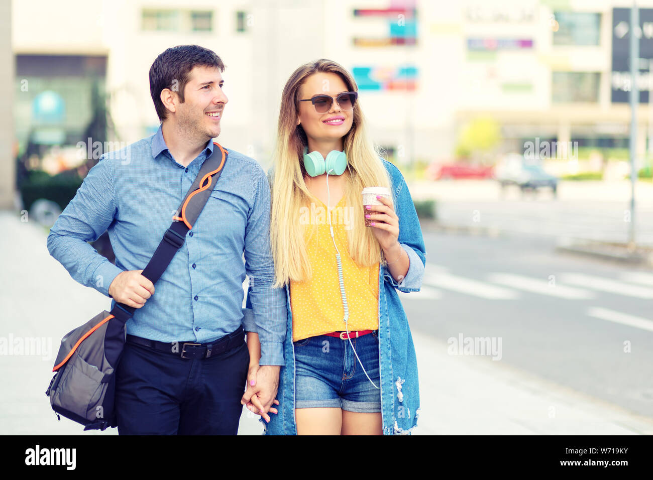 In love modern couple walking on street holding hands Stock Photo