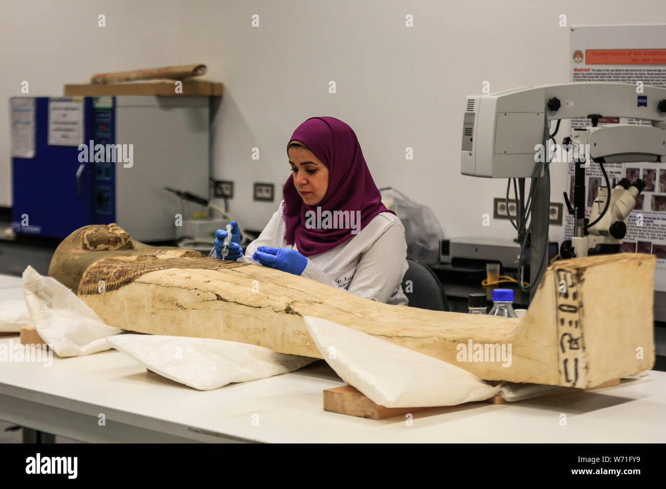 Giza, Egypt. 04th Aug, 2019. An Egyptian archaeologist works on a