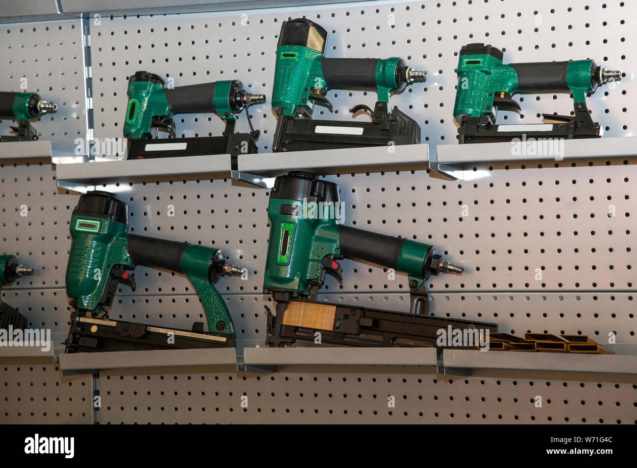 https://c8.alamy.com/comp/W71G4C/set-of-green-power-drills-on-metal-shelves-W71G4C.jpg