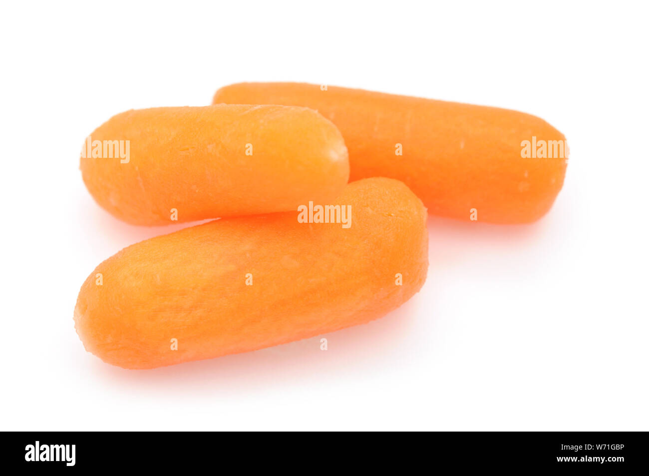 three baby carrots on white Stock Photo Alamy