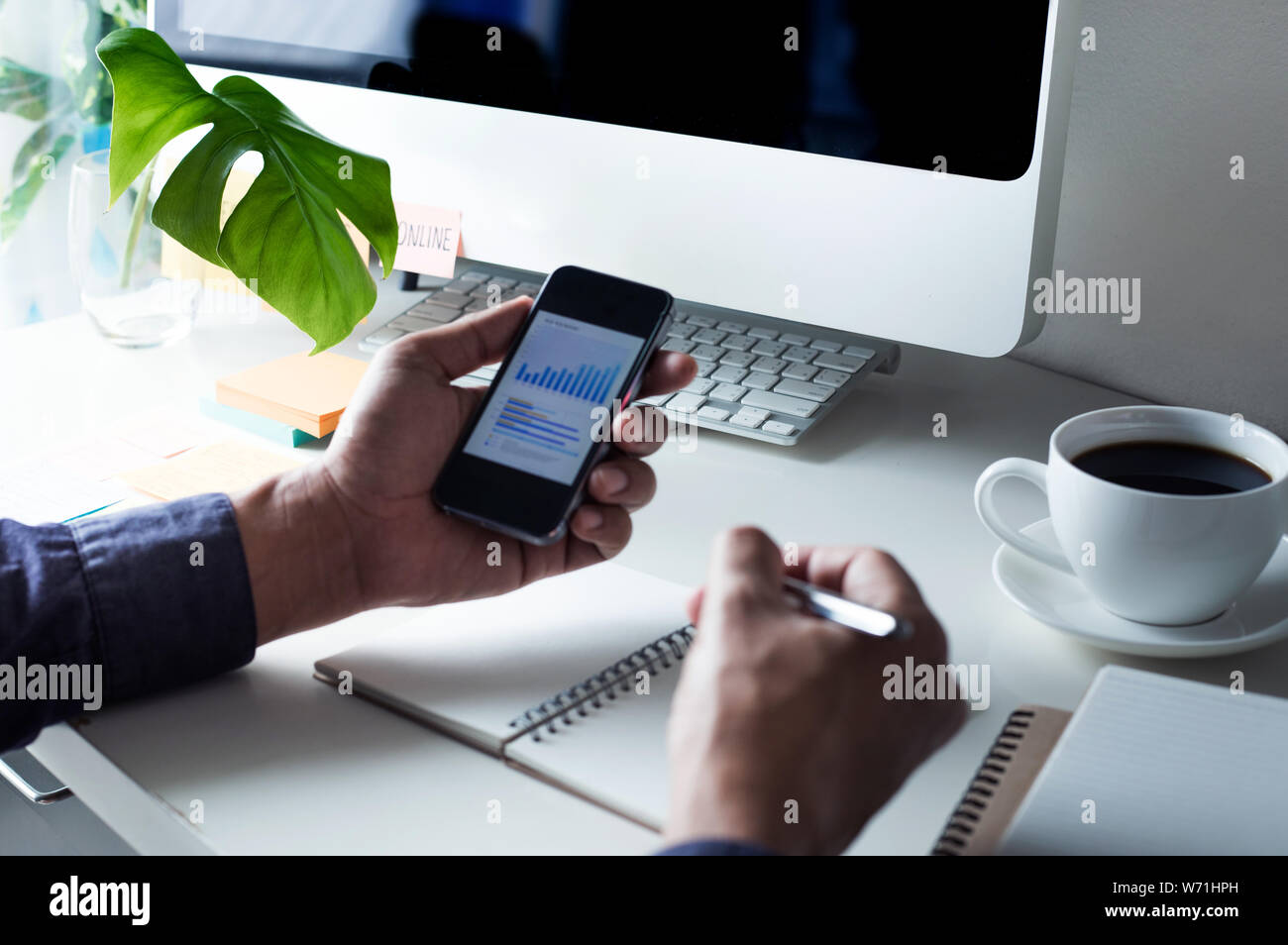 Businessman using (touch screen) smartphone for work with worktable Stock Photo