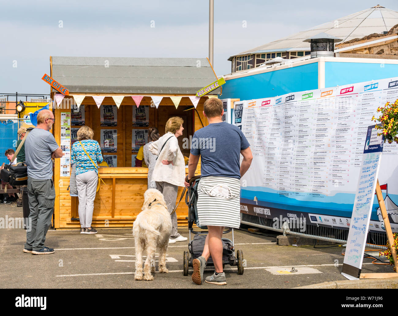 North Berwick, East Lothian, Scotland, UK, 4th August 2019.  Fringe-by-the-Sea is in a relaxed seaside setting with the main venue in  the harbour area. Festival goers browsing the programme and buying tickets
