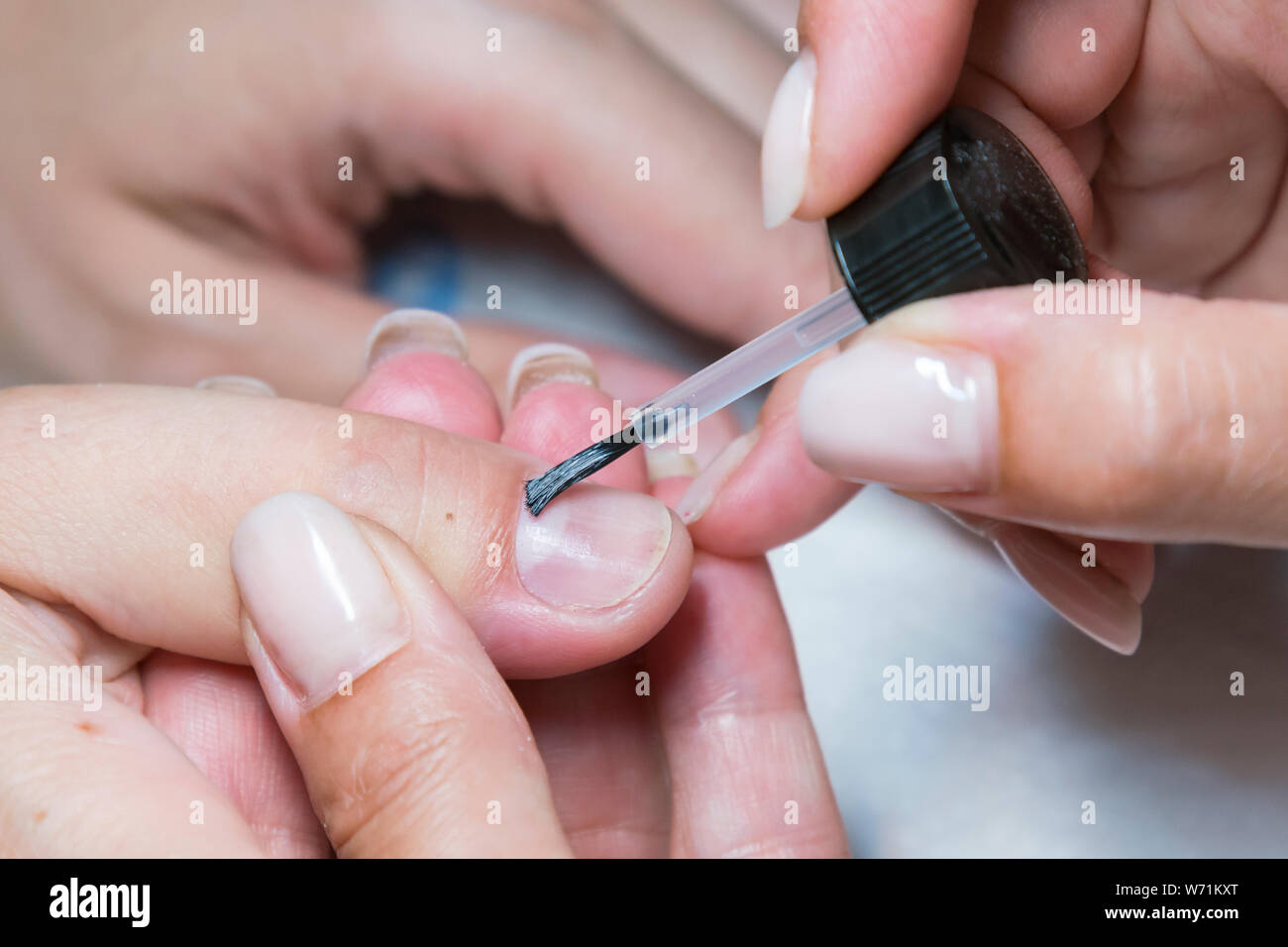woman hand on manicure treatment with cuticle knife in beauty salon
