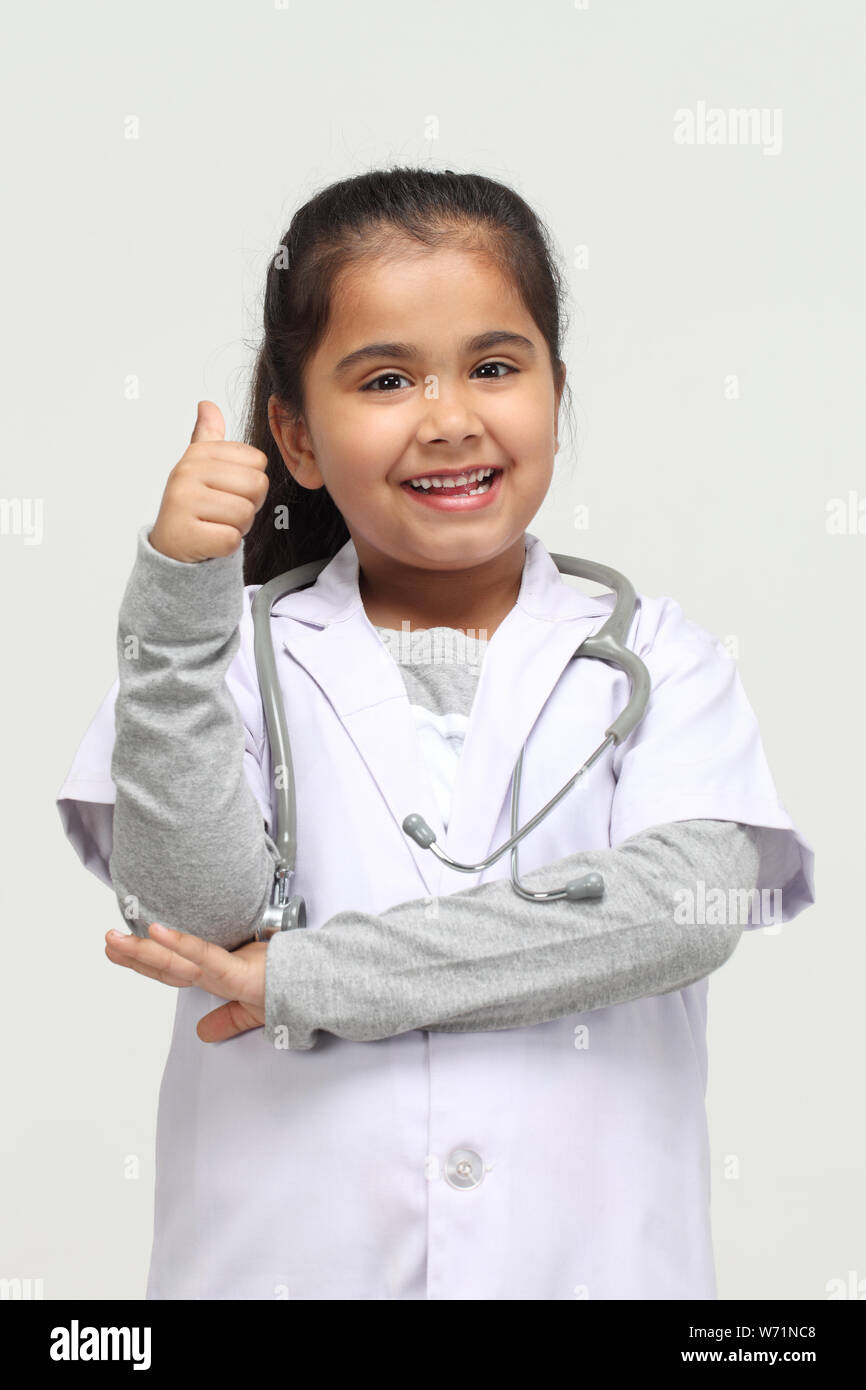 Girl dressed up as a doctor and showing thumbs up sign Stock Photo