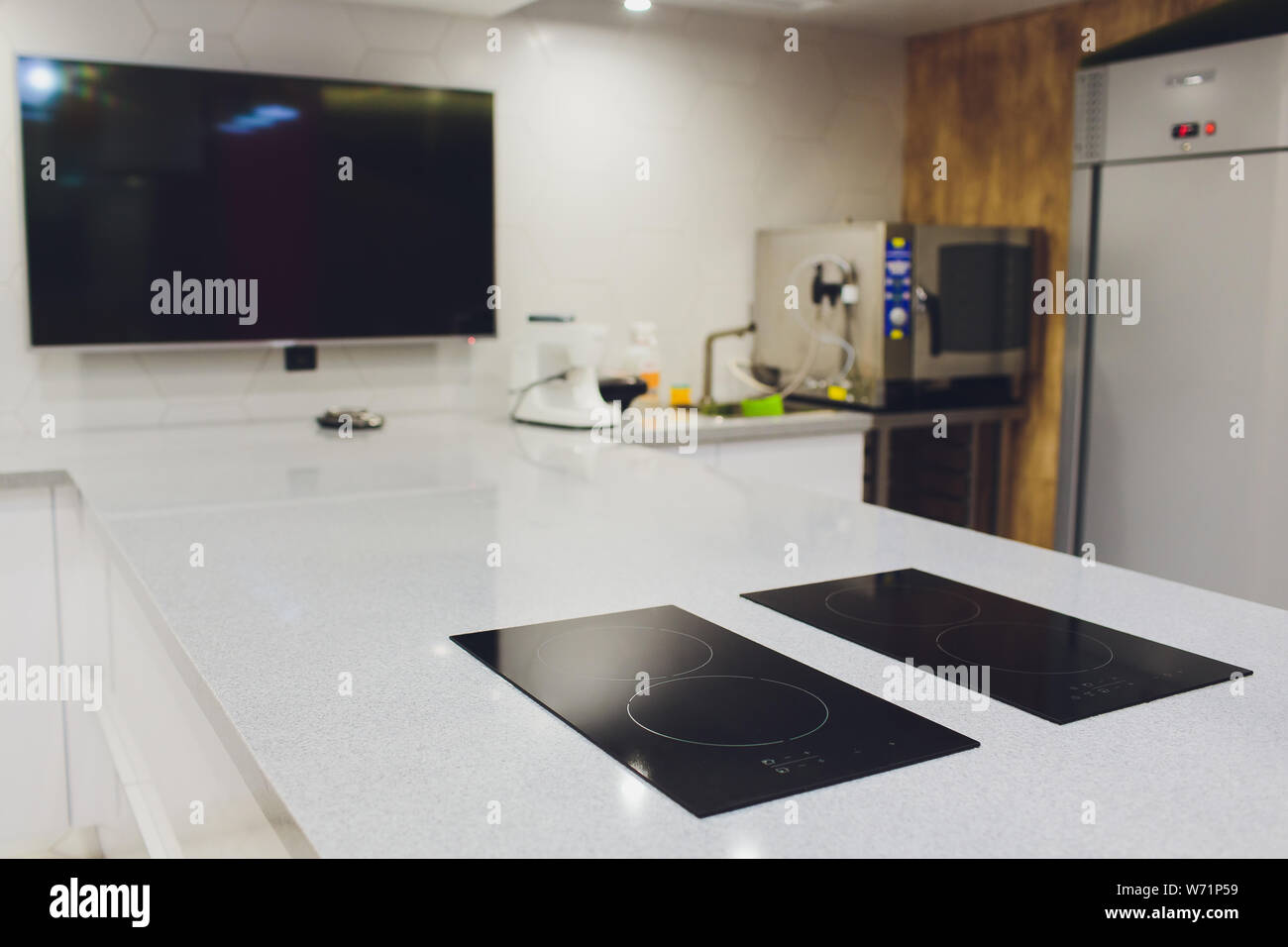 Modern black induction cooker on white countertop. kitchen with island