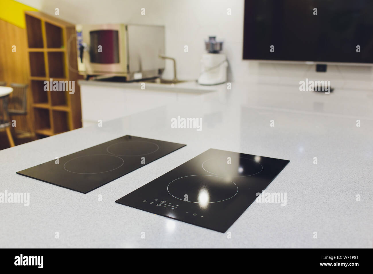 Modern black induction cooker on white countertop. kitchen with island