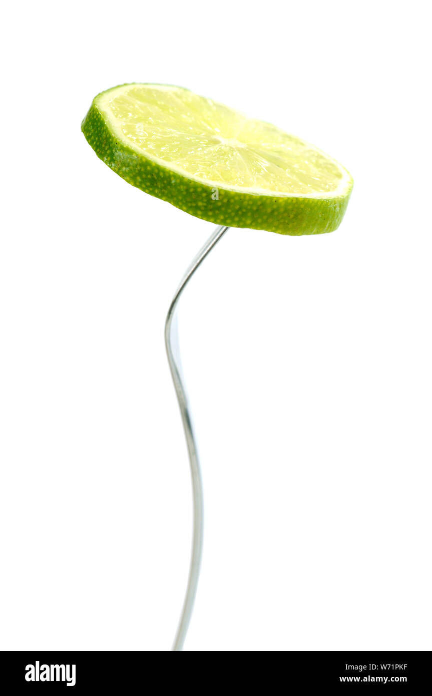 single slice lime in fork isolated on white Stock Photo Alamy