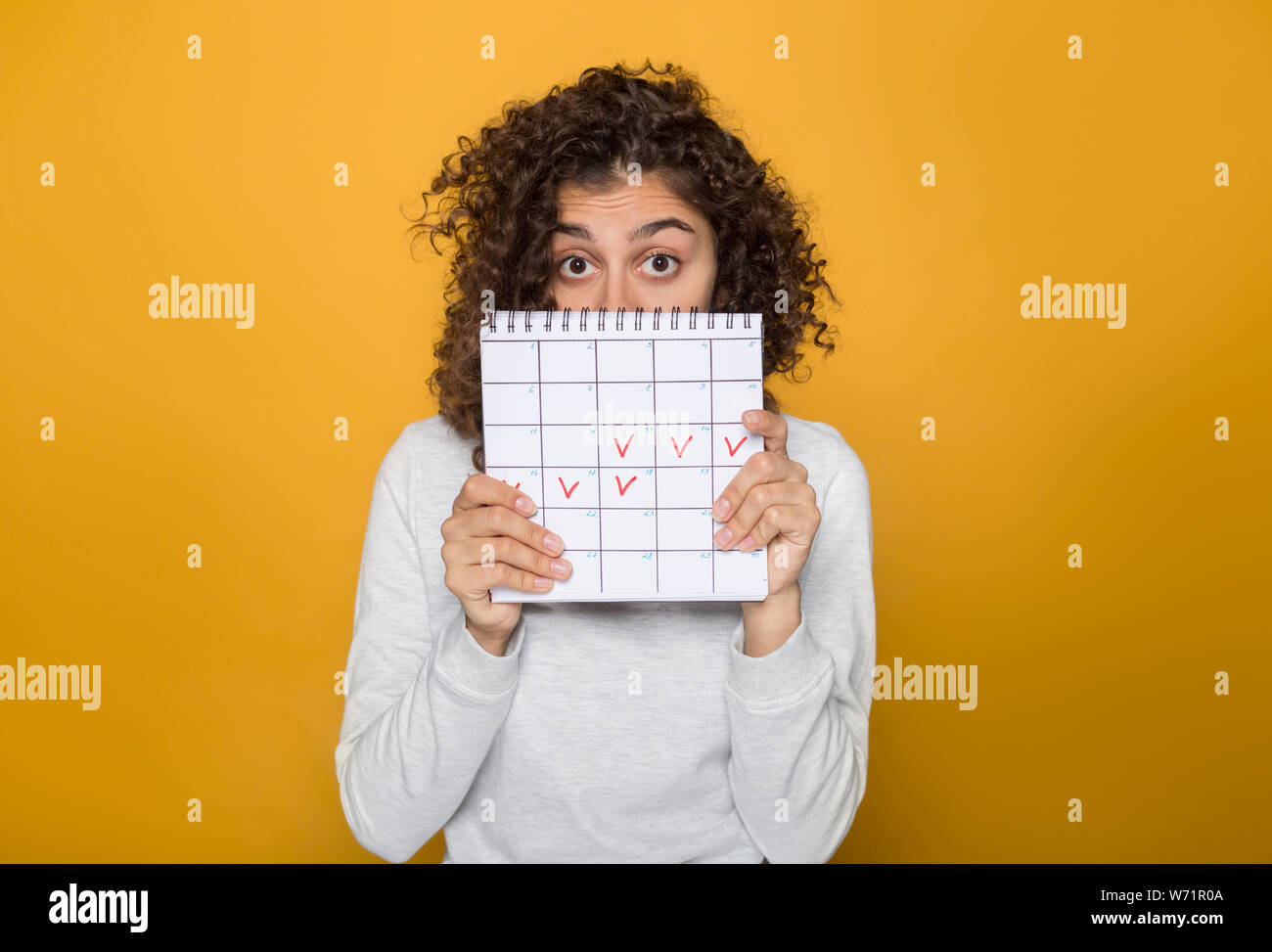 Young woman holds calendar period of menstruation the marks days. Stock Photo
