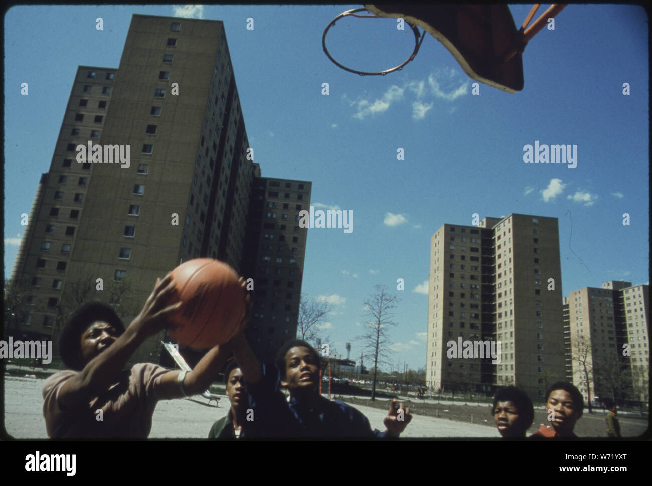 BLACK YOUTHS PLAY BASKETBALL AT STATEWAY GARDENS' HIGHRISE HOUSING PROJECT ON CHICAGO'S SOUTH SIDE. THE COMPLEX HAS EIGHT BUILDINGS WITH 1,633 TWO AND THREE BEDROOM APARTMENTS HOUSING 6,825 PERSONS. THEY WERE BUILT UNDER THE U.S. HOUSING ACTS OF 1949 AND 1968 THEY ARE MANAGED BY THE CHICAGO HOUSING AUTHORITY WHICH IS RESPONSIBLE FOR 41,500 PUBLIC HOUSING DWELLINGS Stock Photo