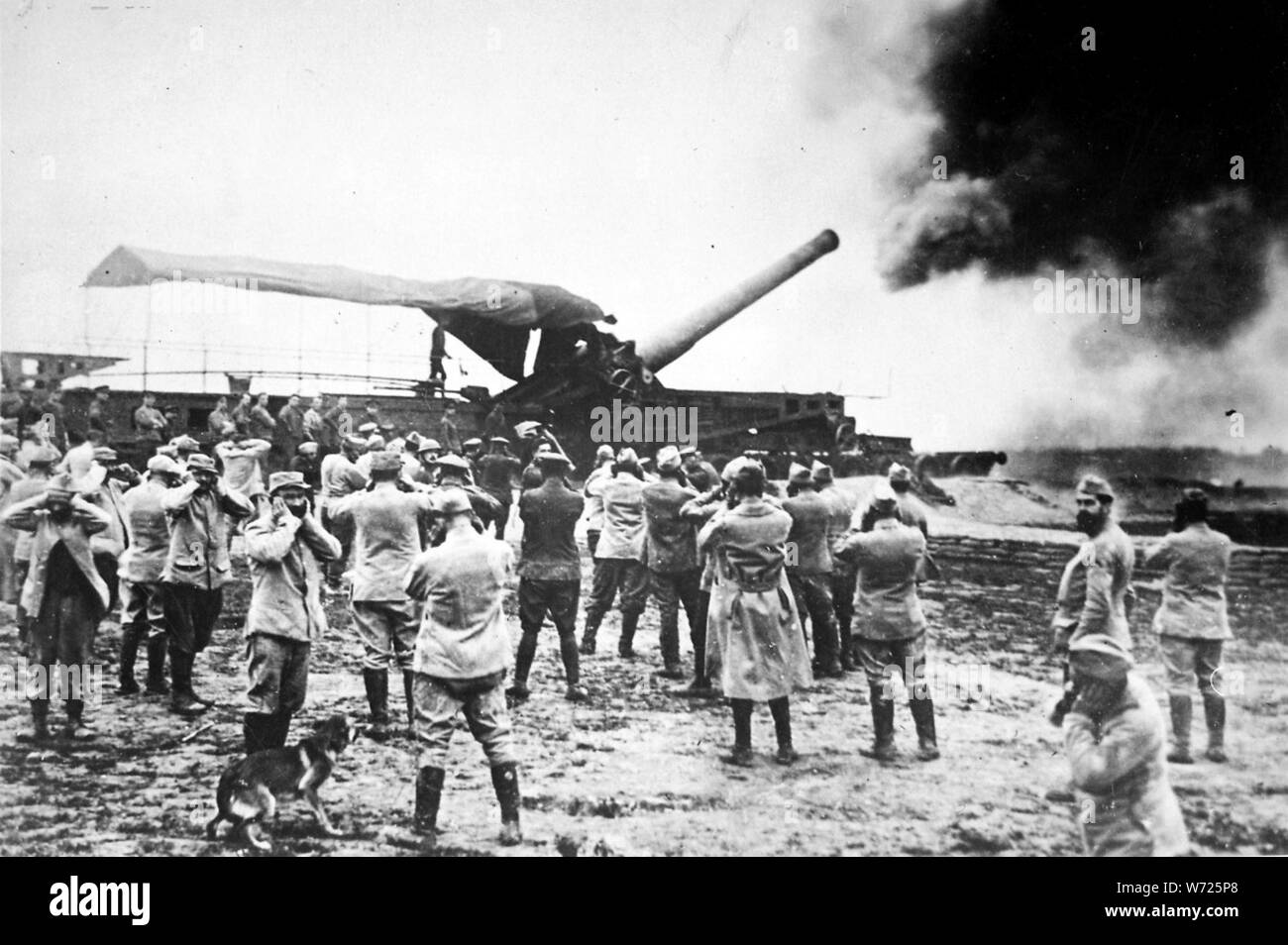 Discharge of a huge French cannon caught by the camera just as the projectile left for the German lines. The gunners have stuffed their fingers into their ears to protect them from noise of explosion. Underwood and Underwood., ca. 1918; General notes:  Use War and Conflict Number 627 when ordering a reproduction or requesting information about this image. Stock Photo