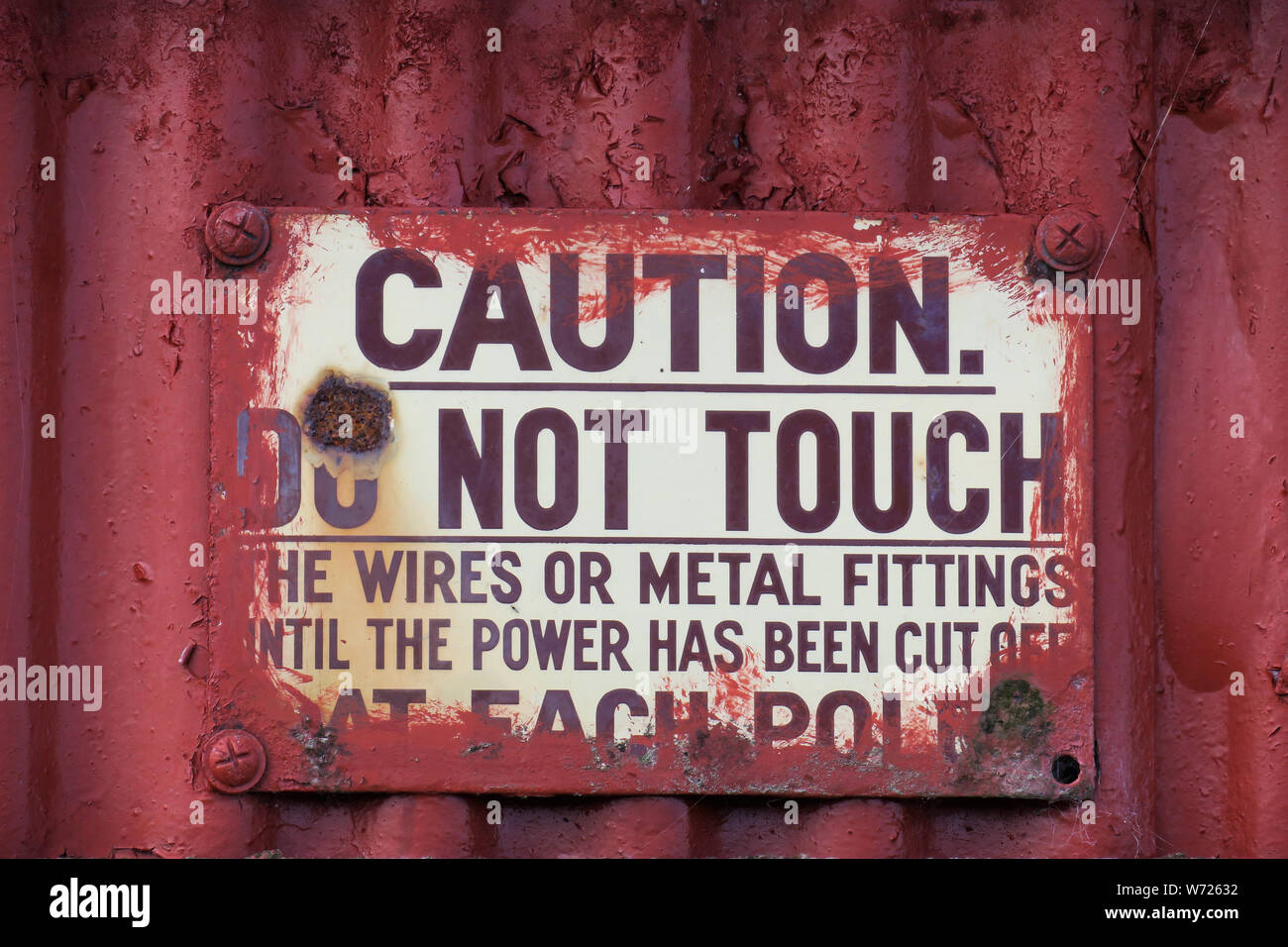 Enameled metal warning sign from a bygone era with design of embossed