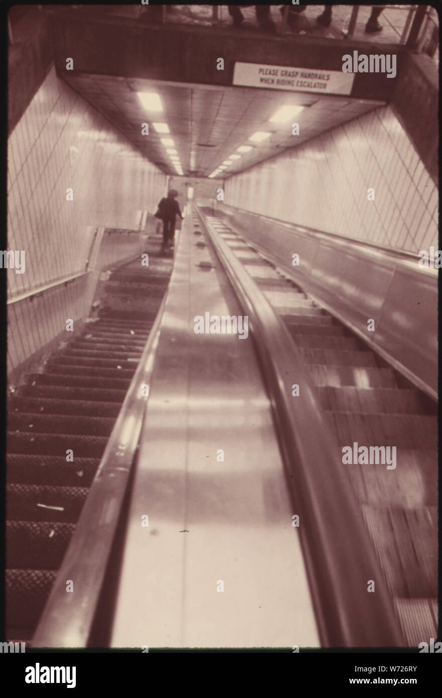 ESCALATOR TRANSPORTS PASSENGERS FAR BELOW THE CITY STREETS TO THE LEXINGTON AVENUE LINE SUBWAY OPERATED BY THE NEW YORK CITY TRANSIT AUTHORITY. THE SYSTEM TRANSMITS SLIGHTLY LESS THAN TWO MILLION PEOPLE TO AND FROM WORK EACH DAY. DESPITE THE CRITICAL IMPORTANCE OF THE SUBWAY FOR COMMUTING, VOTERS HAVE REFUSED TO AUTHORIZE NEW FUNDS FOR ANY MORE IMPROVEMENTS, OR TO ALLOW THE 35-CENT FARE TO BE INCREASED TO COVER OPERATING COSTS Stock Photo
