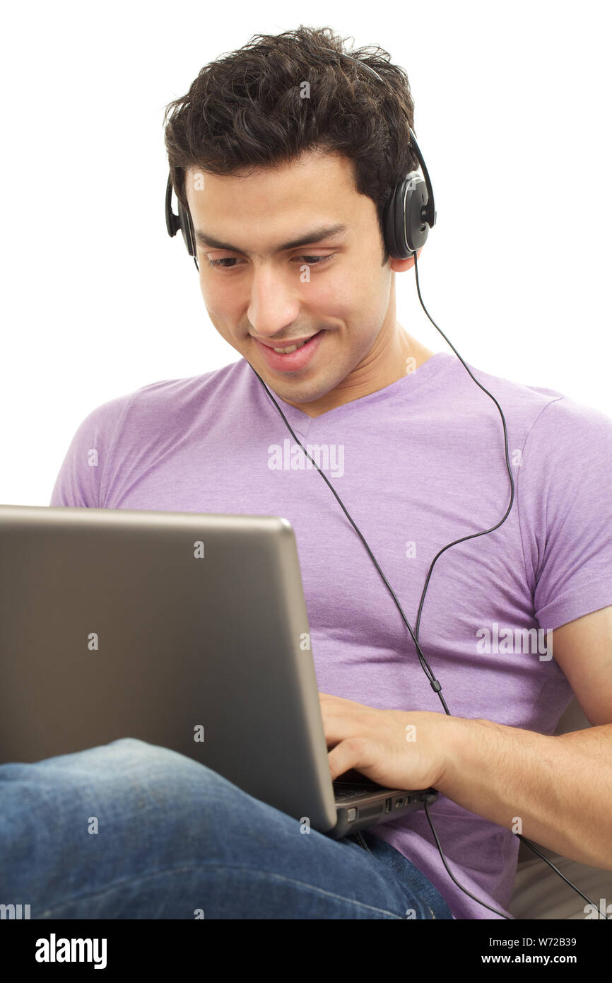 Indian young man wearing headphones and using a laptop Stock Photo - Alamy