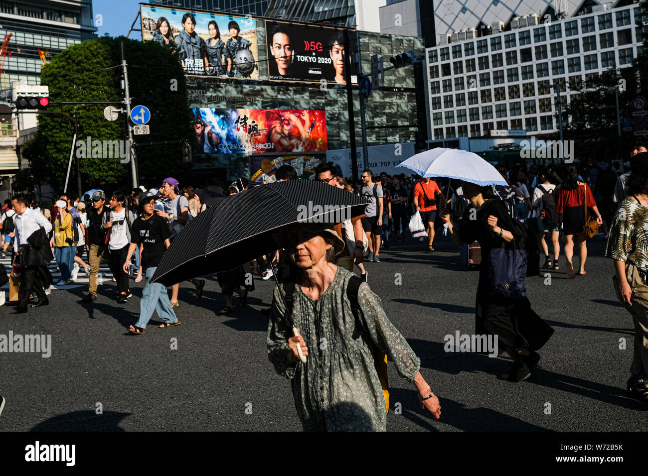 People hold umbrellas at the Shibuya crossing in Tokyo.A deadly heat ...
