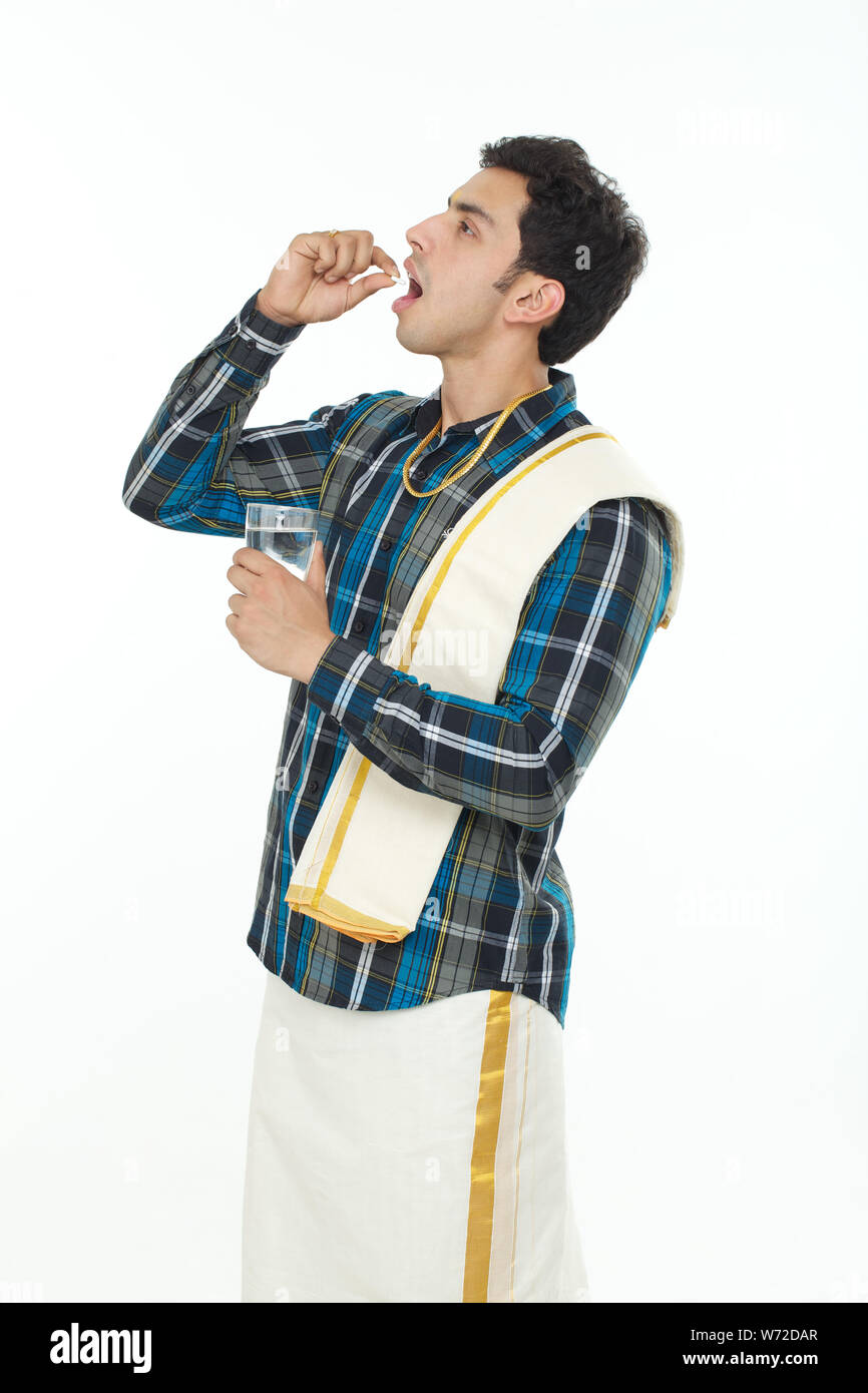 South Indian man taking medicine Stock Photo - Alamy