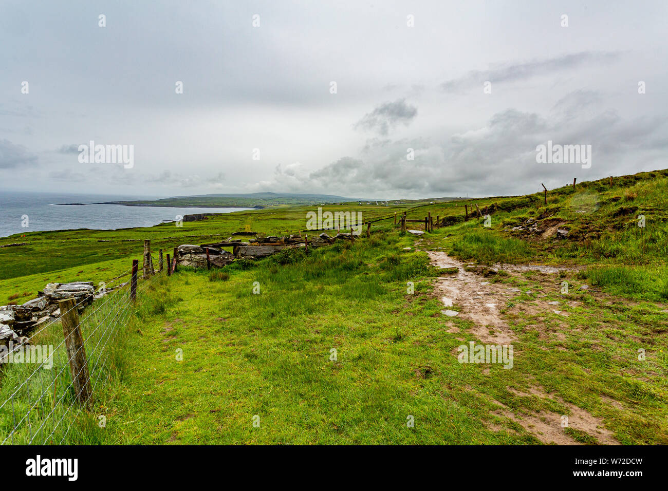 Irish countryside with a rural path between fences in of the coastal