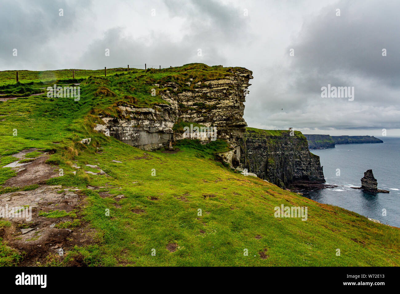 Countryside landscape in the Cliffs of Moher with the Branaunmore sea stack, geosites and geopark, Wild Atlantic Way, wonderful cloudy spring day Stock Photo