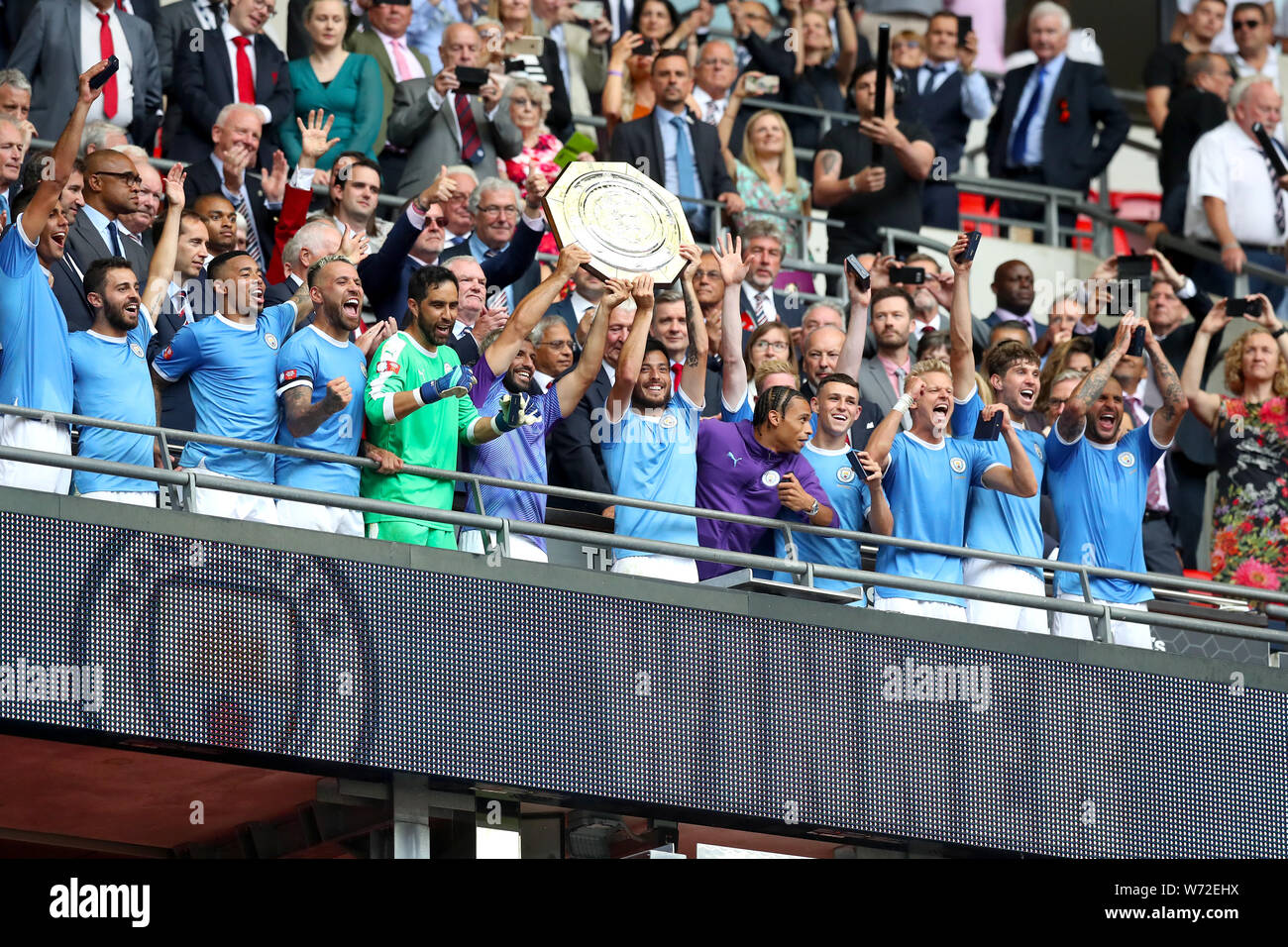 Manchester City's Sergio Aguero and David Silva lift the trophy after their side win the Community Shield match at Wembley Stadium, London. Stock Photo