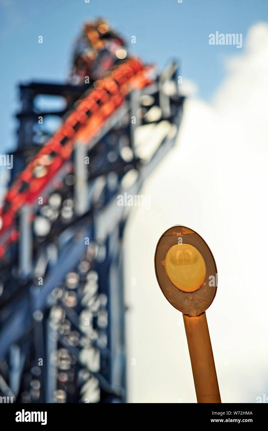 Curved street light in front of a out of focus Big One roller coaster Stock Photo