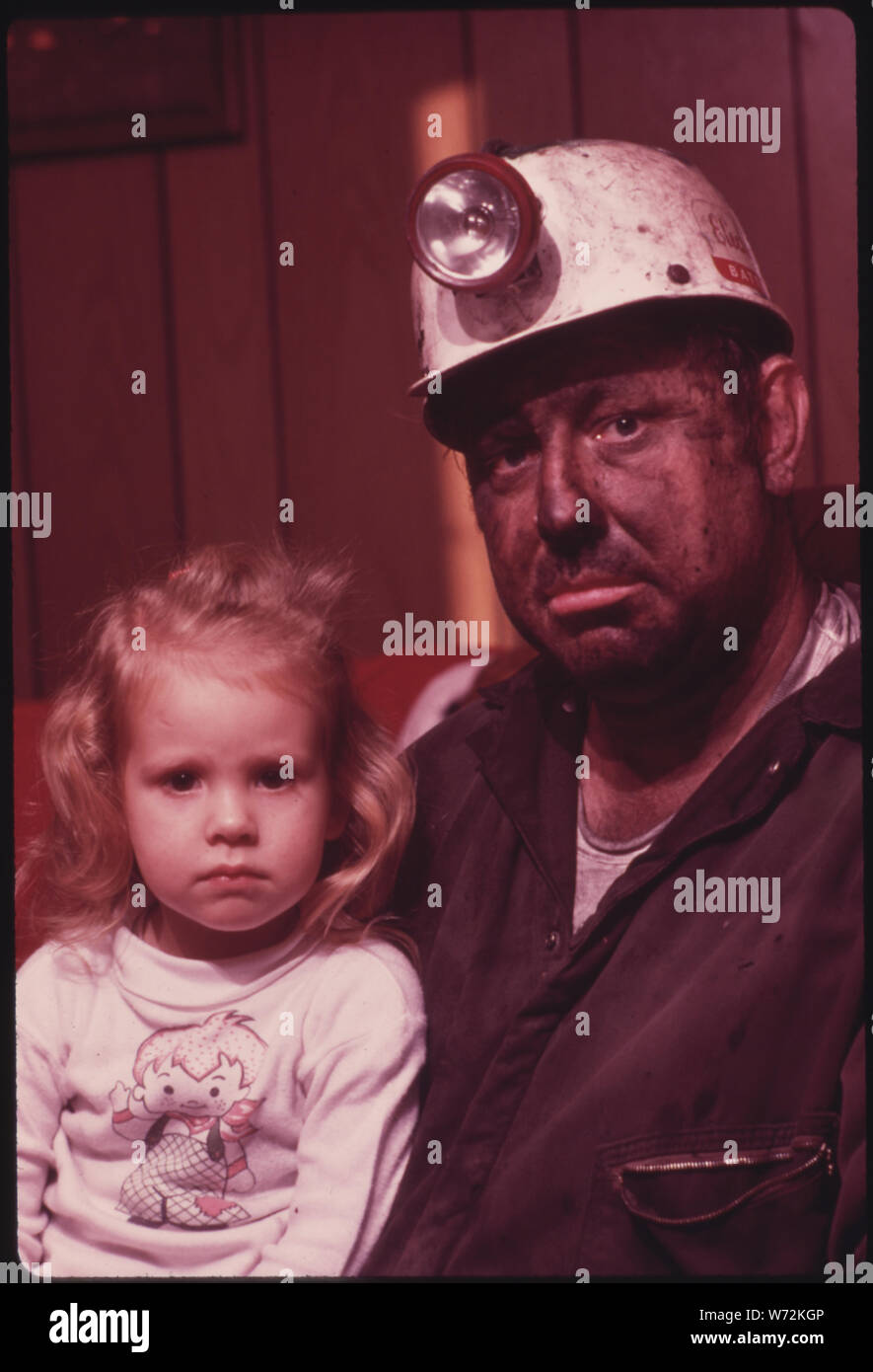 MINER WAYNE GIPSON, 39, WITH HIS DAUGHTER TABITHA, 3. HE HAS JUST GOTTEN HOME FROM HIS JOB AS A CONVEYOR BELT OPERATOR IN A NON-UNION MINE. AS SOON AS HE ARRIVES HE TAKES A SHOWER AND CHANGES INTO CLOTHES TO DO LIVESTOCK CHORES WITH HIS TWO SONS. GIPSON WAS BORN AND RAISED IN PALMER, TENNESSEE, BUT NOW LIVES WITH HIS FAMILY NEAR GRUETLI, NEAR CHATTANOOGA. HE MOVED NORTH TO WORK AND MARRIED THERE, BUT RETURNED BECAUSE HE AND HIS WIFE THINK IT IS A BETTER PLACE TO LIVE Stock Photo