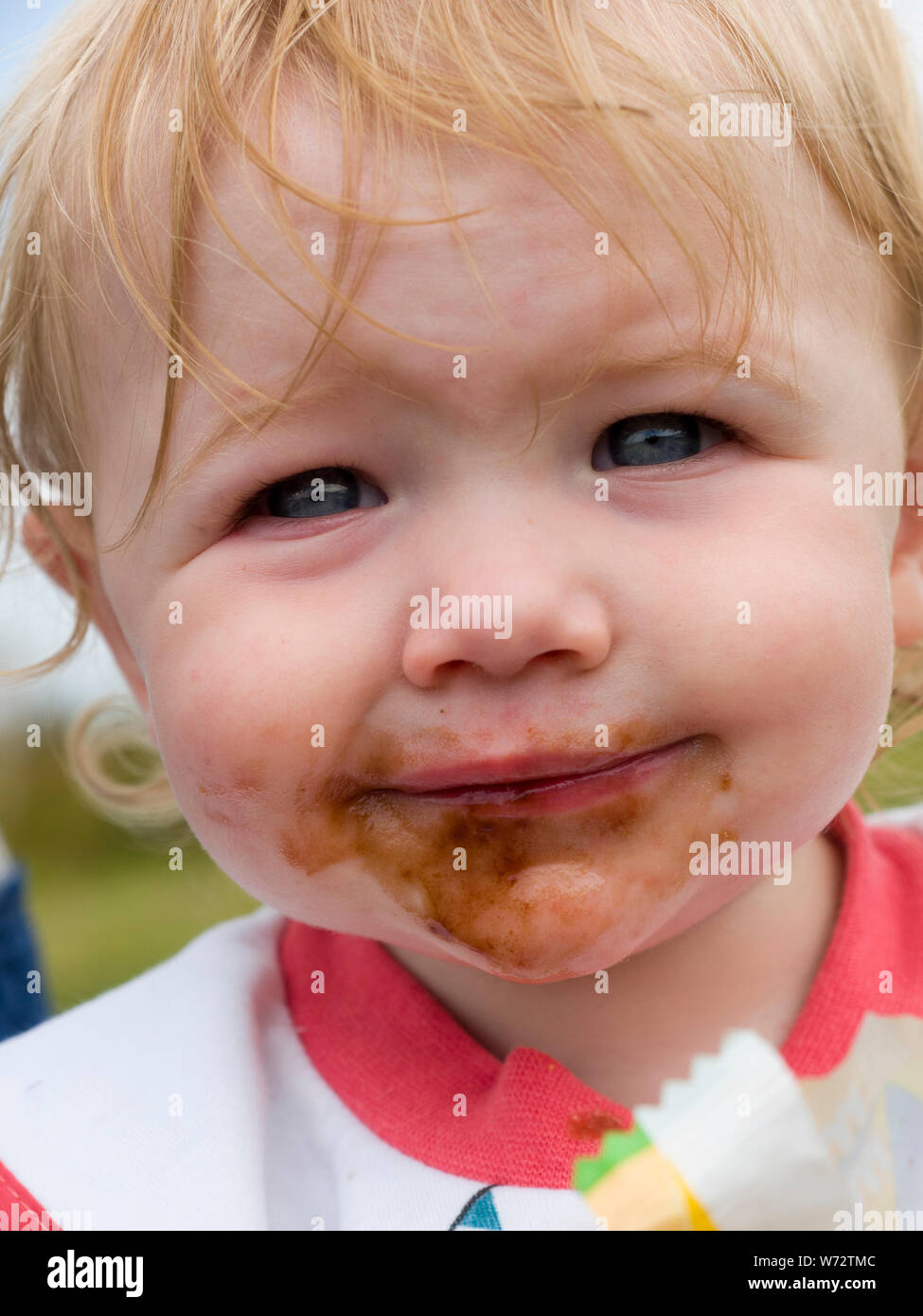 Toddler with dirty face after eating chocolate, UK Stock Photo