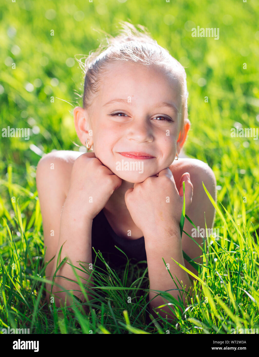 cute happy little girl lying on the grass. Stock Photo