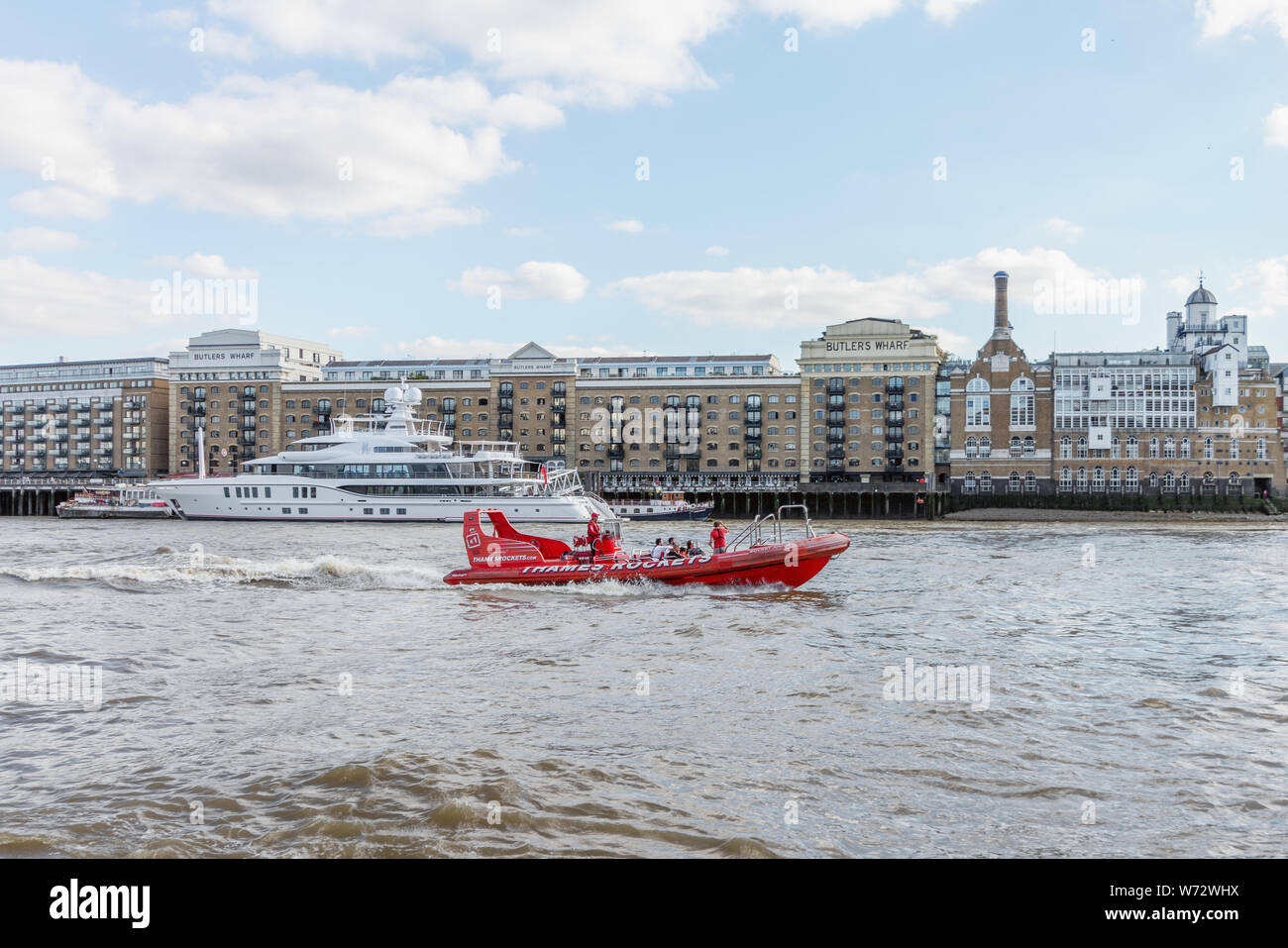 London / UK, July 15th 2019 - Thames Rockets sightseeing speed boat speeding down the Thames River in front of Butlers Wharf Stock Photo