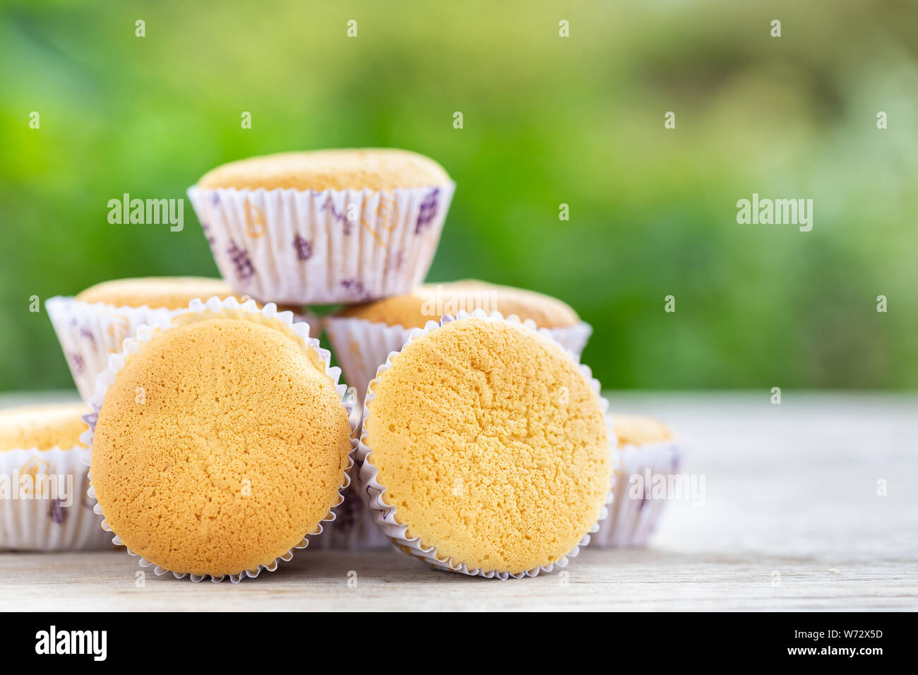 Close up ancient egg cakes (Kanom khai in Thai name) in white paper cup on wooden table Stock Photo