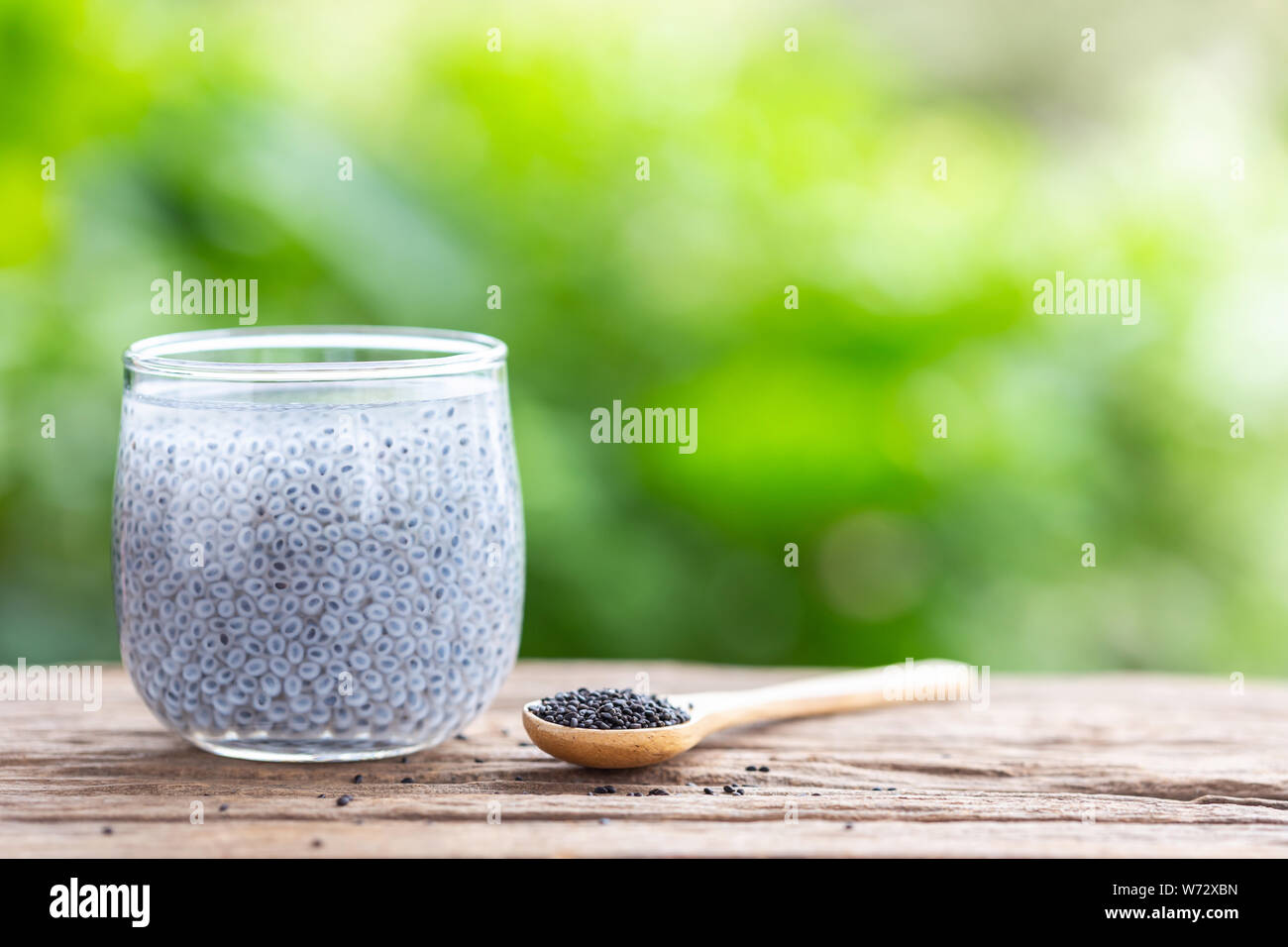Close up lemon basil seeds in glass on wooden table Stock Photo