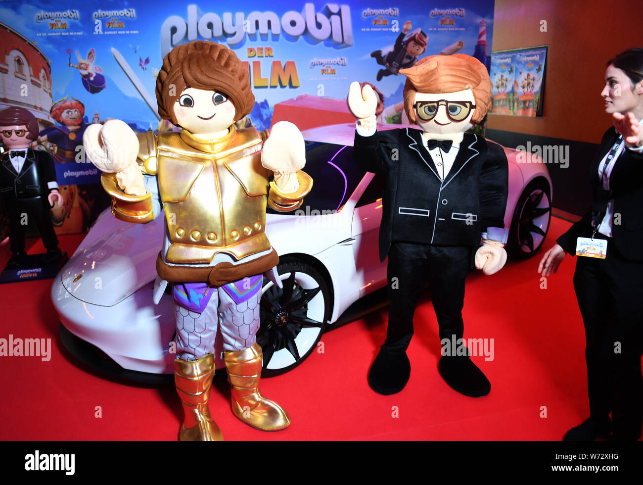 Munich, Germany. 04th Aug, 2019. Living Playmobil characters stand in front  of a Porsche at the film premiere "Playmobil - the film" on the red carpet  in the Mathäser cinema. The animated