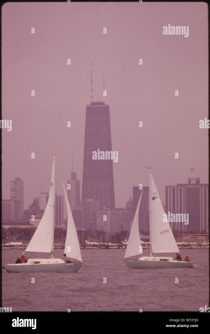 Photograph of Sailboats Near the Lake Michigan Shoreline; Scope and content:  Original caption: Sailboats near the Lake Michigan shoreline with downtown Chicago in the background.  The 110 story Sears Tower, billed as the world's tallest building in early 1974, is seen between the sailboats Barely visible at the extreme left is the Standard Oil building, the second tallest structure in Chicago. Stock Photo