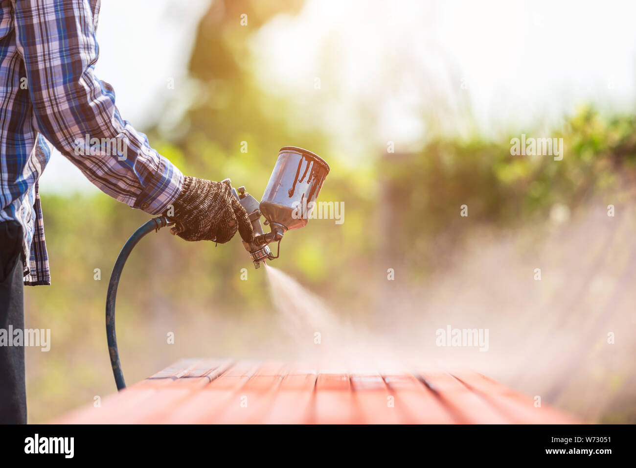 Construction worker spraying paint to steel pipe to prevent the rust on the surface Stock Photo