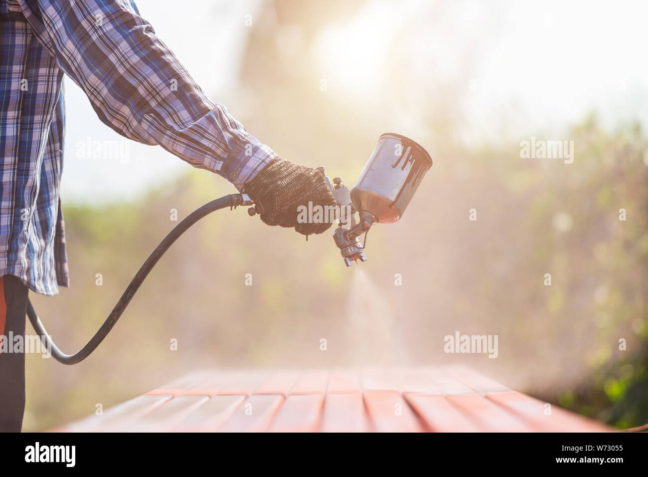 Construction worker spraying paint to steel pipe to prevent the rust on the surface Stock Photo